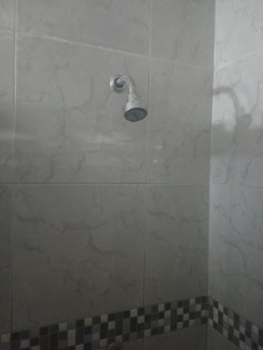 una doccia con porta in vetro e soffione di Casa na praia de Touros a Touros