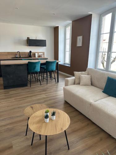 un salon avec un canapé et une table dans l'établissement Appartement de la gare, à Remiremont