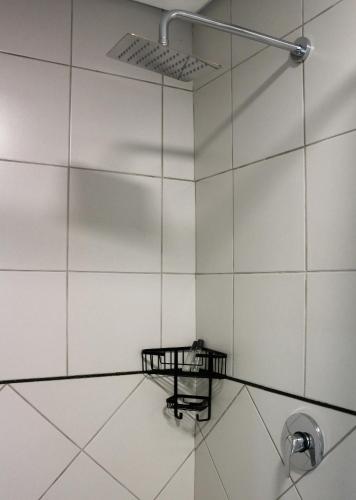 a bathroom with white tile walls and a shower at Luxury Heights Bed and Breakfast in Newcastle