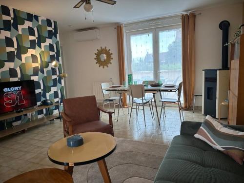 un salon avec un canapé et une table dans l'établissement Maison Seventies climatisée, parking privé, à Chablis
