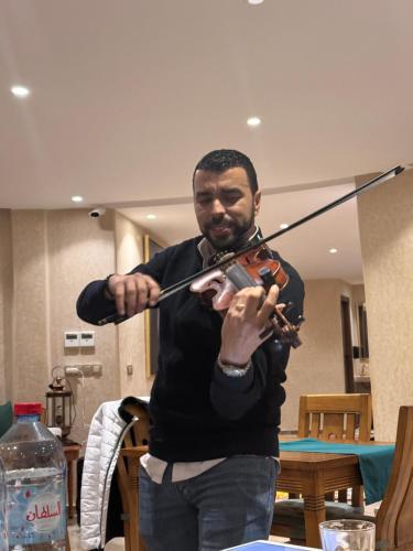 a man playing a violin in a room at Bhalil Farm House in Sefrou
