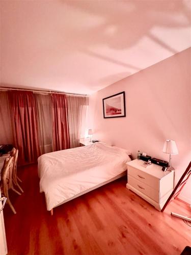 une chambre avec un lit blanc et une table de chevet dans l'établissement Charming flat beside Champs-Élysées, à Paris