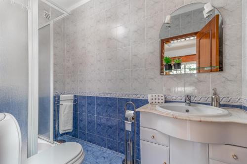a bathroom with a toilet sink and a mirror at Villa Audiência 38 in Monte Gordo