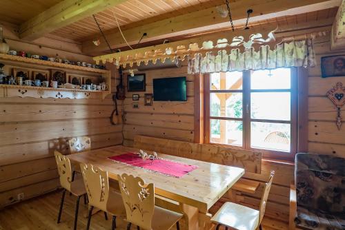 a dining room with a wooden table and chairs at Jaworówka na Polnej in Nowy Targ
