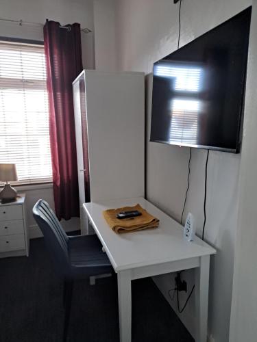 a desk with a chair and a television on a wall at Southfield lodge in Middlesbrough