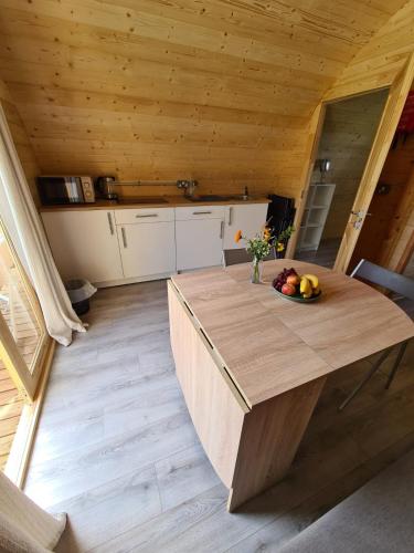 a wooden table in a kitchen with a bowl of fruit at Gouladoo Retreat in Bantry
