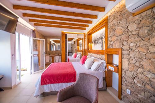 a bedroom with two beds and a stone wall at Hotel Rural Rosario Martin in Puerto del Rosario