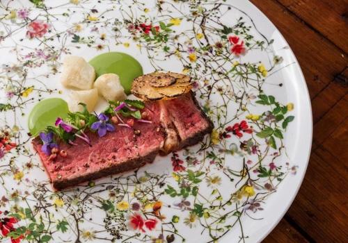 a white plate with a piece of food on it at Sackmann Genuss und Spa Resort in Baiersbronn