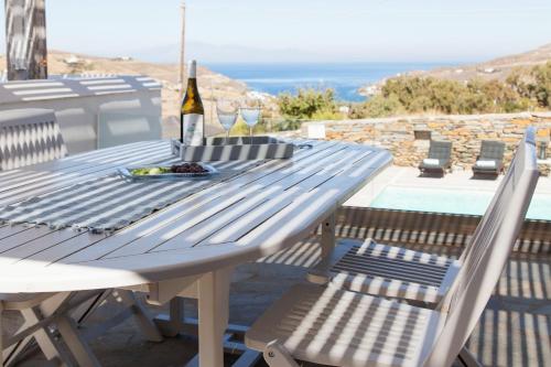 a picnic table with a bottle of wine and two chairs at Kea Villa Thea by A&D Properties in Otzias