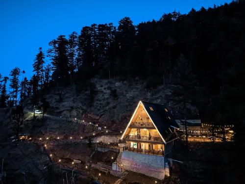 a house on a hill at night with lights at The Bagh Kufri in Kūfrī