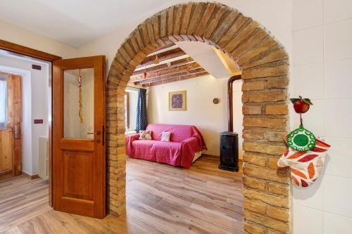 einen Torbogen in einem Wohnzimmer mit einer roten Couch in der Unterkunft Il cuore delle dolomiti in Vinigo
