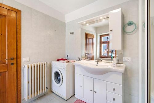 ein Badezimmer mit Waschmaschine und Waschbecken in der Unterkunft Il cuore delle dolomiti in Vinigo