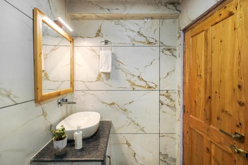 a bathroom with a sink and a mirror at The Bagh Kufri in Kūfrī