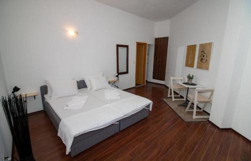 a bedroom with a large white bed and a table at Apartments Isabella in Mostar
