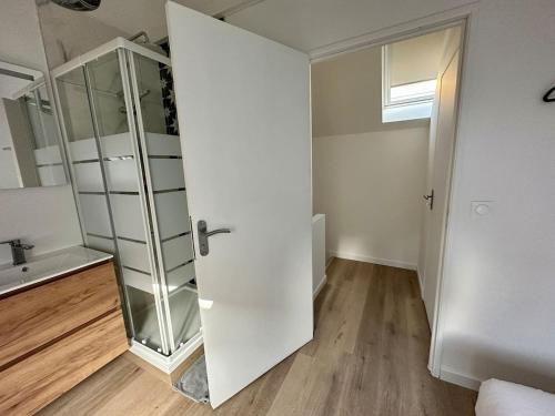 une porte ouverte dans une chambre avec salle de bains. dans l'établissement Mascate - Appartement avec terrasse privée et climatisation, à Reims