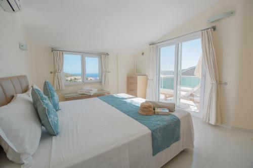 a bedroom with a large bed with a view of the ocean at Sunset Apartments with pool in Kalkan in Kalkan