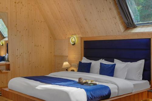 a bedroom with a large bed with a blue headboard at The Bagh Kufri in Kūfrī