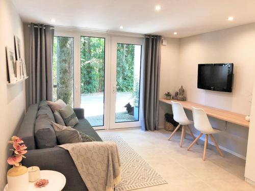 Una sala de estar con un sofá y un televisor. en Lifestyle Apartment, en Schwabach