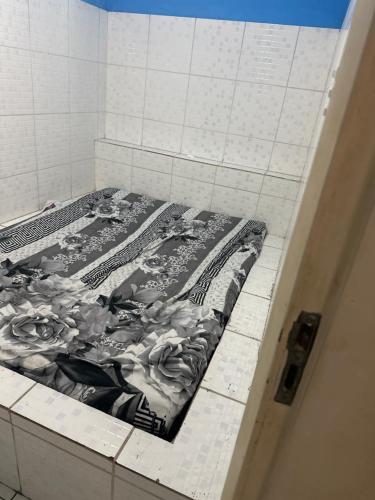 a bed sitting on a tiled floor in a bathroom at Yellow house 1 in Salvador