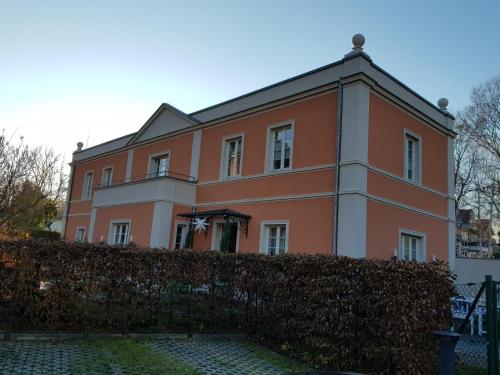 a large orange building with a fence in front of it at Remise Heiliger See in Potsdam