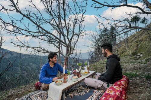 two men sitting at a table on a mountain at The Bagh Kufri in Kūfrī