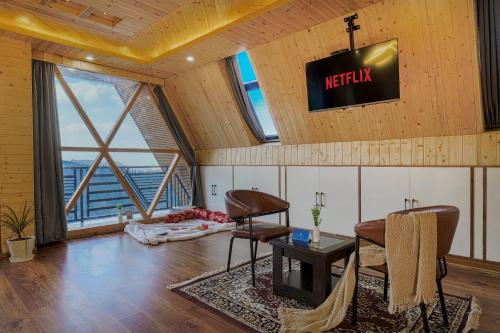 a living room with a television on the wall at The Bagh Kufri in Kūfrī