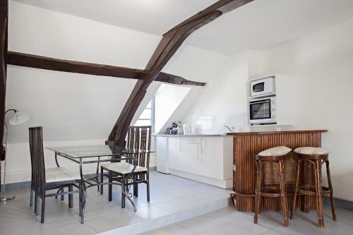 une cuisine et une salle à manger avec une table et des chaises dans l'établissement Appartement de charme, à Honfleur