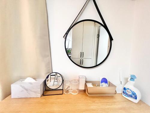 a mirror on a table with a shelf with items at HeiStay-30sec from Hongdae SubwayStop-Elevator in Seoul