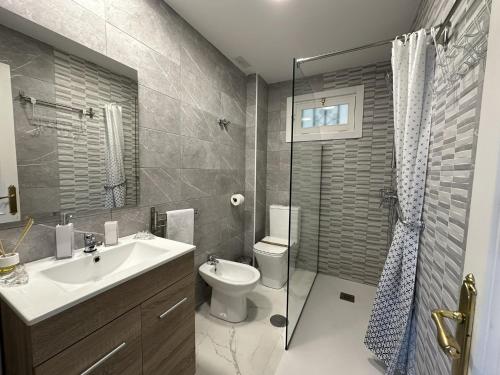 Un baño con lavabo, inodoro y ducha. en Apartamento en pleno centro de Torremolinos, en Torremolinos