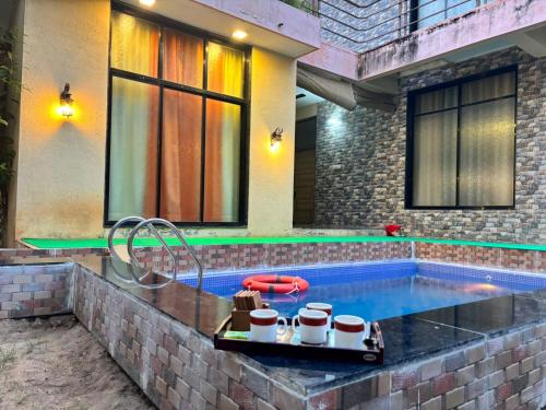 a swimming pool with a tray of coffee cups in it at Suman Madhu Mansion in Nānodra