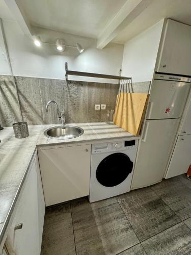 une cuisine avec un évier et un micro-ondes dans l'établissement Studio Le Marais Saint Paul, à Paris