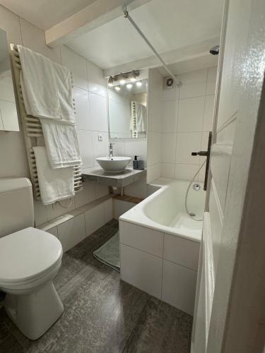 une salle de bain blanche avec des toilettes et un lavabo dans l'établissement Studio Le Marais Saint Paul, à Paris