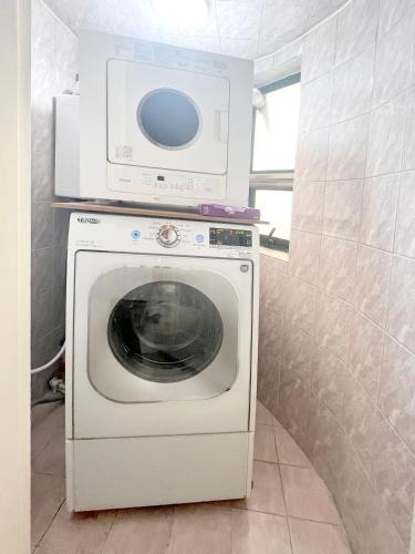 a washing machine with a microwave on top of it at HeiStay-30sec from Hongdae SubwayStop-Elevator in Seoul