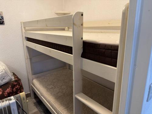 Ce lit superposé blanc se trouve dans un dortoir. dans l'établissement HOLIDAYLAND Résidence Les Balcons de la Méditerranée 2, à Narbonne-Plage