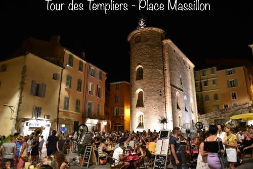 a crowd of people sitting in chairs in front of a building at Le Port Plage Studio tout confort Terrasse Clim in Hyères