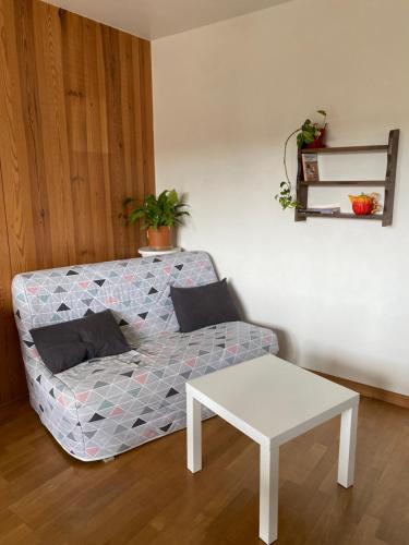 a couch and a table in a room at Chez Doukine, Appartement avec balcon à Chouzelot in Chouzelot