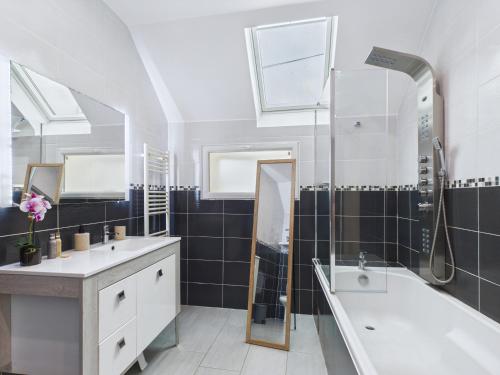 une salle de bain avec deux lavabos, une baignoire et une douche dans l'établissement Maison face à l'île Venan pour 2 personnes, à Plouguerneau