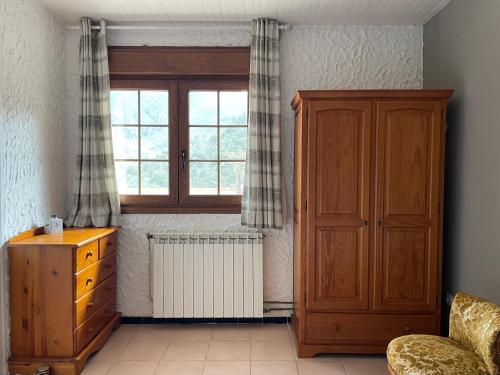 une pièce avec une armoire en bois et une fenêtre dans l'établissement Casa Sola Apartment, stunning views, private pool, à Arles-sur-Tech