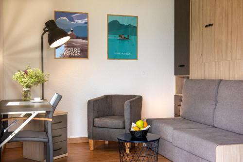a living room with a couch and a chair at L'Ecrin du Lac in Chorges