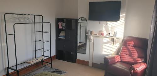 a living room with a chair and a mirror at Miner's Retreat Comfy 2-Bed Home, Swadlincote in Woodville