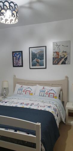 a bedroom with a bed with pictures on the wall at Miner's Retreat Comfy 2-Bed Home, Swadlincote in Woodville