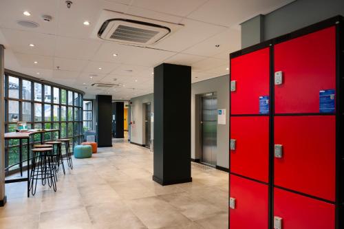 a hallway with red lockers in a office with a bar at B&B HOTEL São Paulo Luz - Centro in Sao Paulo