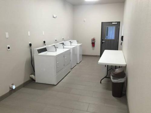 een badkamer met een rij wastafels en een tafel bij MainStay Suites Odessa I-20 in Odessa