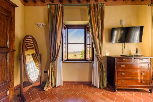 a room with a window and a dresser and a mirror at Villa Delia Hotel and Cooking School in Ripoli