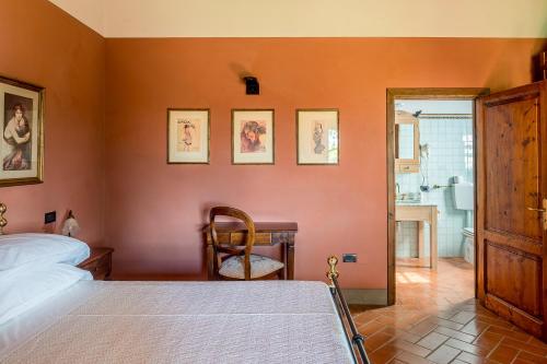 a bedroom with a bed and a desk and a chair at Villa Delia Hotel and Cooking School in Ripoli