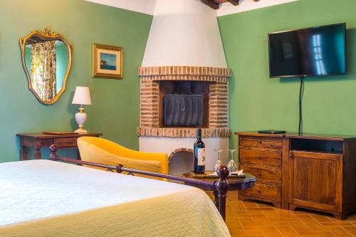 a bedroom with a bed and a fireplace and a television at Villa Delia Hotel and Cooking School in Ripoli