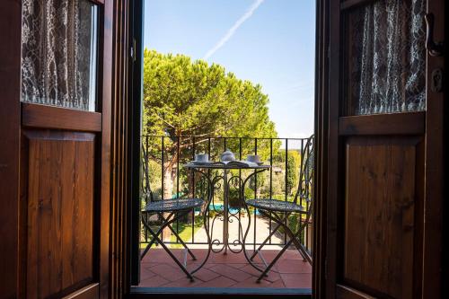 an open door with a table and chairs on a balcony at Villa Delia Hotel and Cooking School in Ripoli