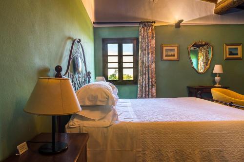 a bedroom with a bed with a lamp and a window at Villa Delia Hotel and Cooking School in Ripoli