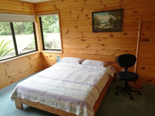 1 dormitorio con 1 cama y 1 silla en Beaver Farm House en Bombay