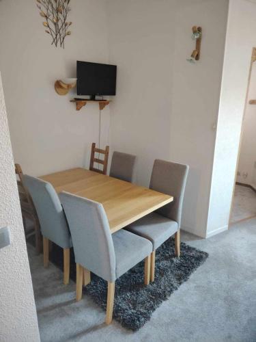une table à manger en bois avec des chaises et une télévision dans l'établissement Appartement avec mezzanine, à Morillon